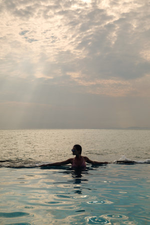 Sexy woman relaxing in the pool with infinity edgeの写真素材