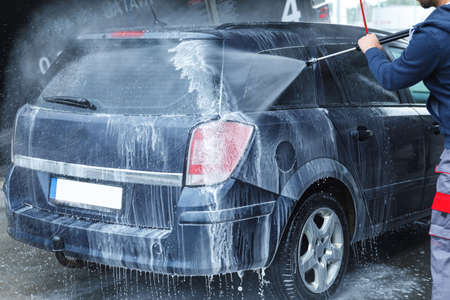 Car wash worker is washing clients carの写真素材