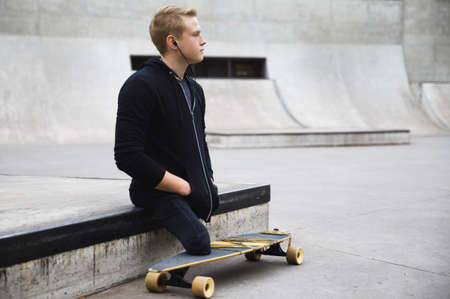 Motivated handicapped guy with a longboard in the skateparkの写真素材
