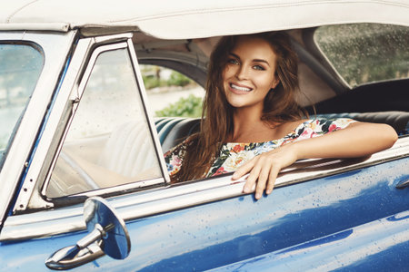 Beautiful woman driving a retro convertible car