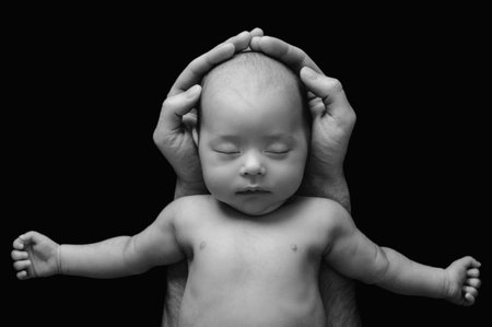 Cute newborn baby in the fathers handsの写真素材