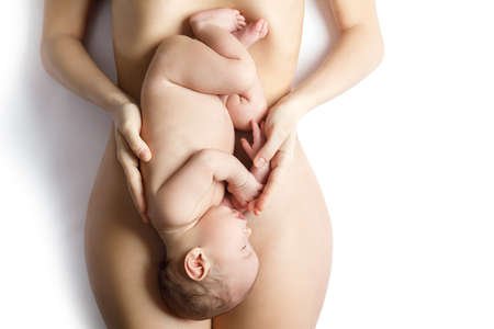 Cute newborn baby lying on the mother bellyの写真素材