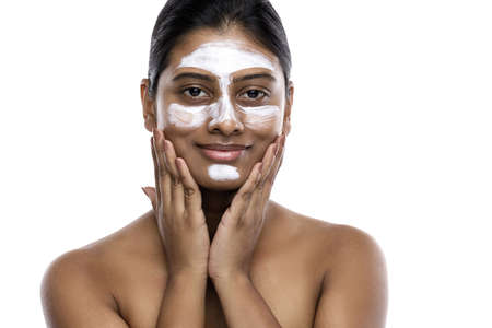Young indian woman with a cleansing mask applied on her faceの写真素材