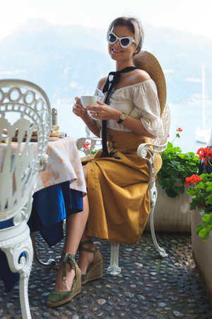 Woman sitting in the street Italian cafe during her breakfastの写真素材