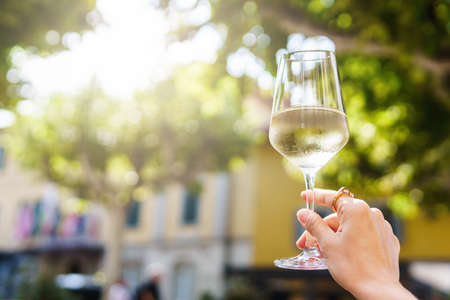 Hand with a glass of white wineの写真素材