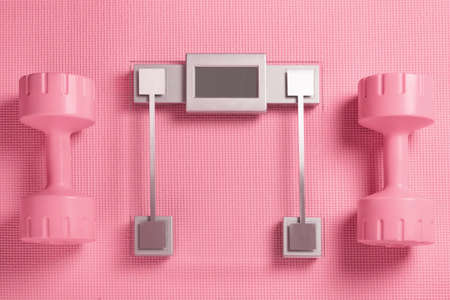 Dumbbells and bathroom scale on the fitness matの写真素材
