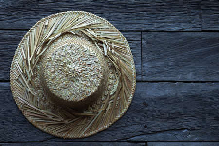 Straw hat against a old wooden surfaceの写真素材