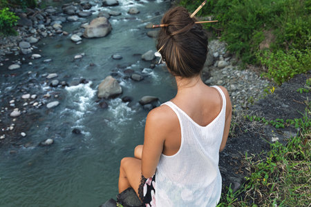 Young woman sitting and looking at the river