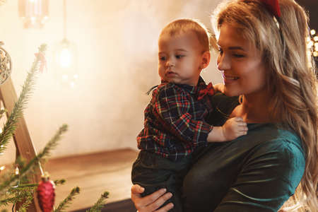 Happy mother and her cute little son are celebrating Christmas or New year.の写真素材