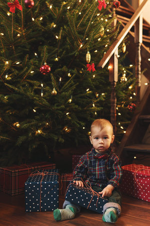 Little boy wearing checkered shirt at home during Christmas eve.