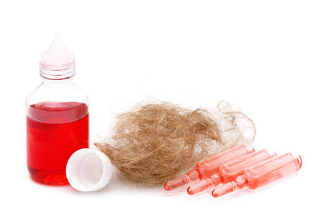 Ampoules with special serum and bottle with oil for hair loss prevention