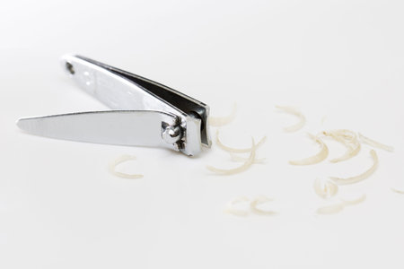 Clipper and dirty nails on white background