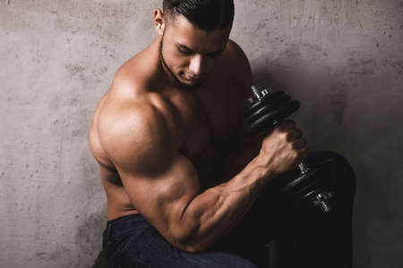 Massive bodybuilder doing biceps curl exercise with the dumbbellの写真素材