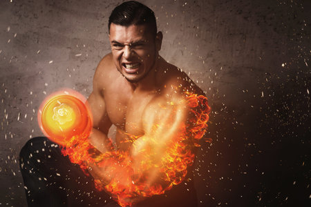 Bodybuilder with burning arm during bicep exercise with the dumbbell