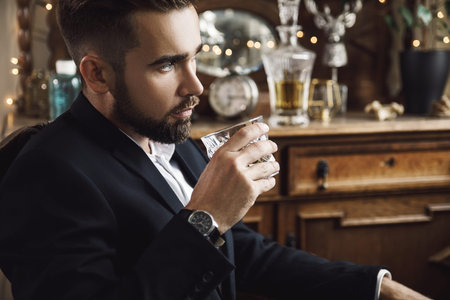 Handsome bearded man with a glass of whiskey