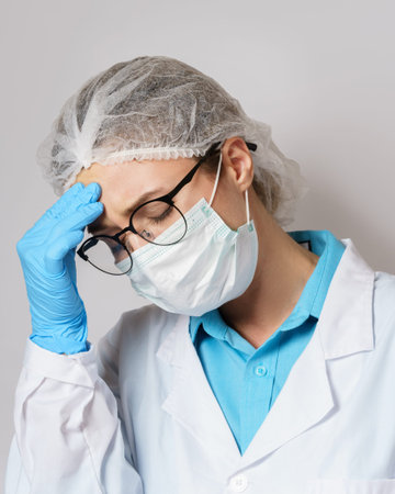 Tiredness - young female doctor with a headache