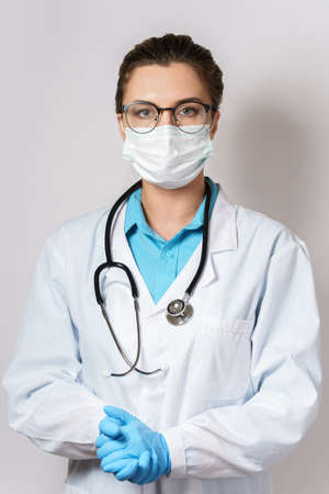 Female doctor with a stethoscope on gray backgroundの写真素材