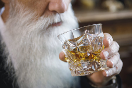Handsome bearded senior man with a glass of whiskey