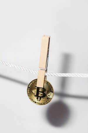 Bitcoin is hung on a rope with clothespins.の写真素材