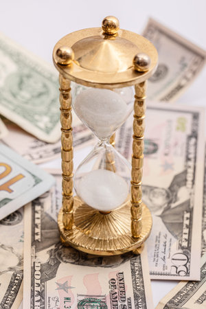 Hourglass and US dollar banknotes. Concept of investment and inflation.