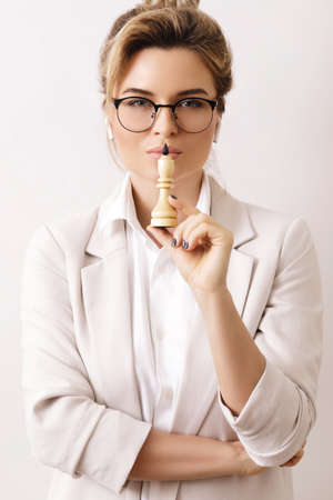 Smart businesswoman holding chess figure in her handの写真素材