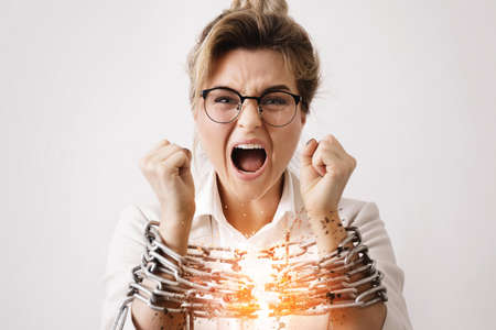 Businesswoman tied up with a chains is screamingの写真素材
