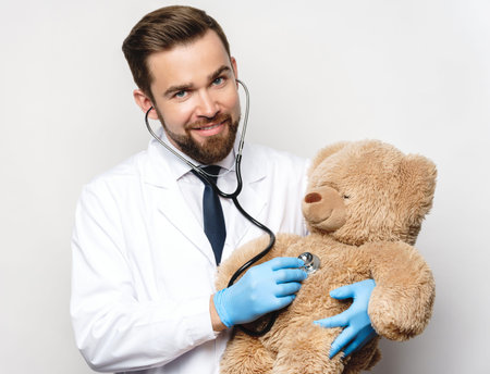 Professional pediatrician with a teddy bear in his hands