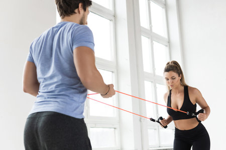 Young woman during workout with a personal fitness instructor in the gym