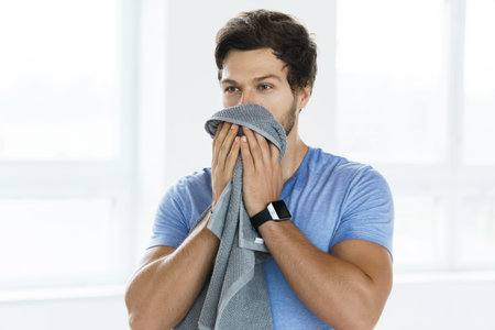 Tired sweaty man after fitness workout in the gym