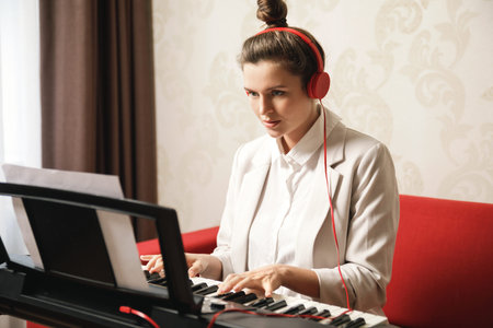 Young woman musician playing synthesizer at home