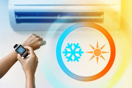 Climate control with a smartwatch. Woman using ACの写真素材