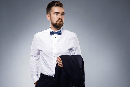 Stylish handsome man wearing a classic suit with bow-tie