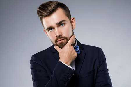 Stylish handsome man wearing a classic suit with bow-tieの写真素材