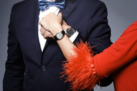 Closeup of well dressed stylish couple wearing wristwatches