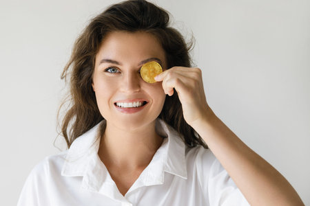 Young woman with a Bitcoin cryptocurrency on gray background