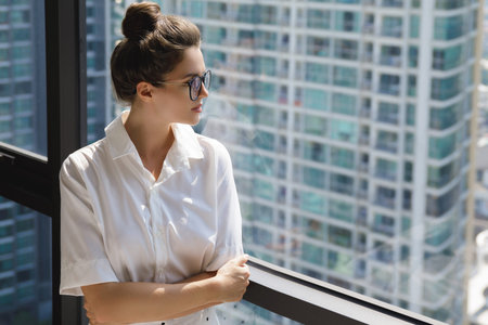 Young businesswoman in her office in the modern building of big city