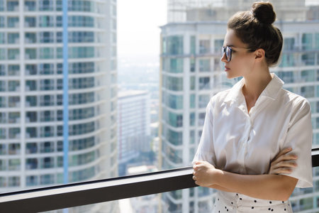 Young businesswoman in her office in the modern building of big city