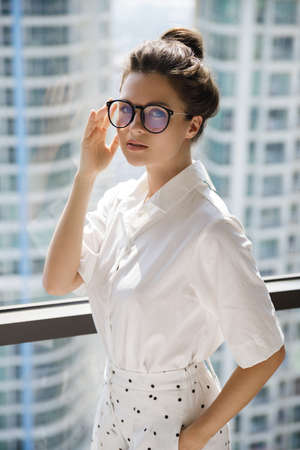 Young businesswoman in her office in the modern building of big cityの写真素材