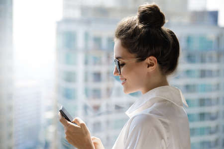 Young businesswoman using smartphone in her officeの写真素材