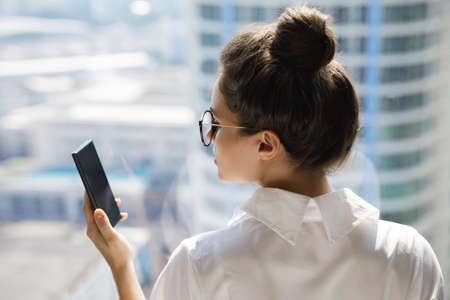 Young businesswoman using smartphone in her officeの写真素材