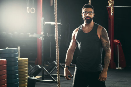Handsome muscular trainer in the cross training gym
