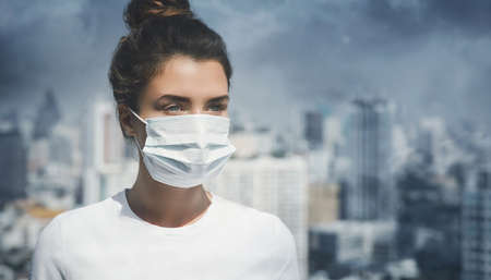 Woman wearing face mask because of air pollution or virus pandemic in the cityの写真素材