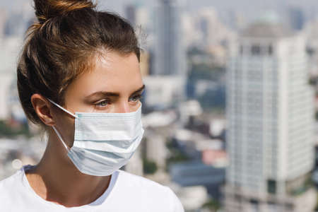 Woman wearing face mask because of air pollution or virus pandemic in the cityの写真素材