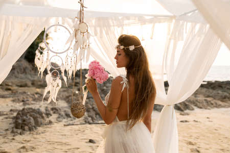 Young beautiful bride celebrating wedding on the beachの写真素材