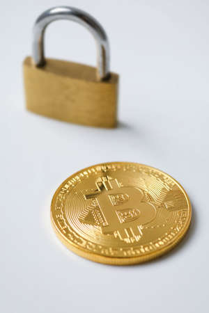 Bitcoin coins and padlock on white backgroundの写真素材