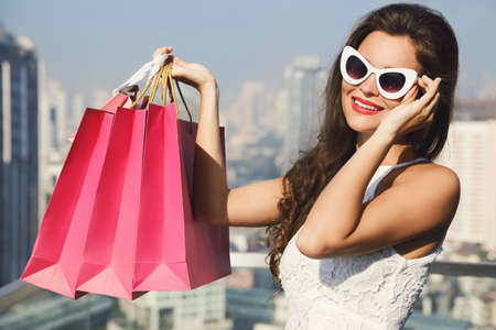 Beautiful woman with a shopping bags in the big and modern cityの写真素材