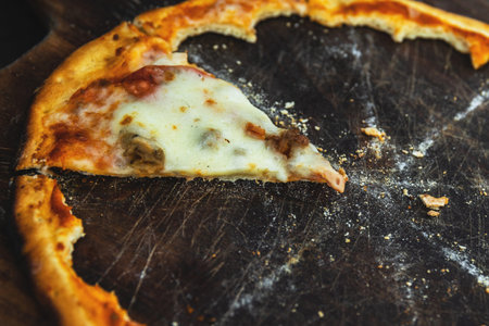 Last piece of delicious pizza on the wooden board