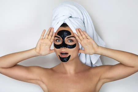 Young and beautiful woman with black peel-off mask on her faceの写真素材