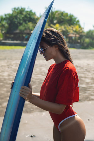 Sexy woman surfer with shortboard on the beach