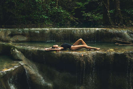 Sexy woman in the jungle with beautiful waterfallの写真素材